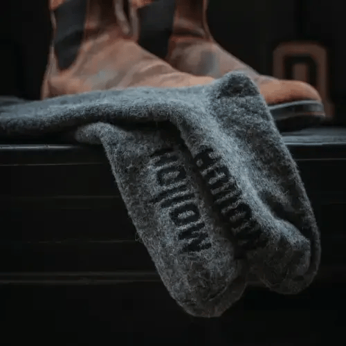 Picture of a guy pulling up boot socks on this leg.